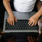 A child and adult using a laptop together, emphasizing learning and guidance.